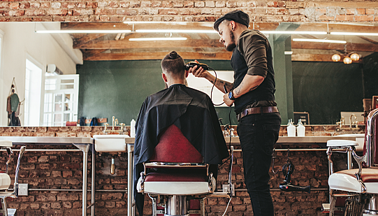 A barber and their client enjoying the music in the salon