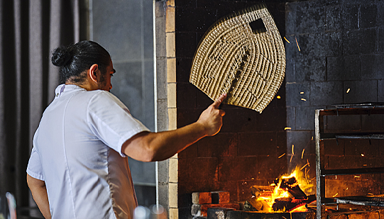 Executive chef Henry Onesemo fans flames in the TALA kitchen