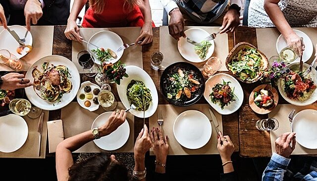 Top down photograph of a table filled with food on white plates