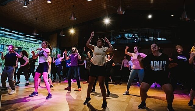 A large group of people dancing indoors